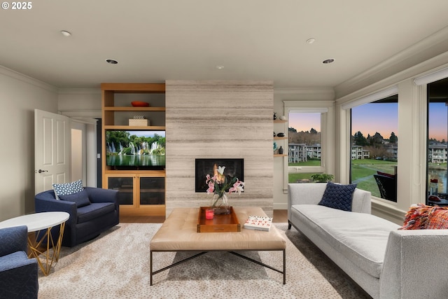 living room featuring a large fireplace, ornamental molding, wood finished floors, and recessed lighting