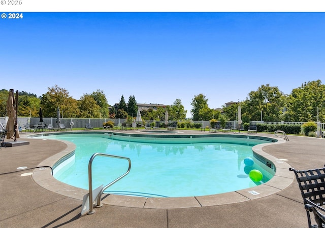 community pool with fence and a patio