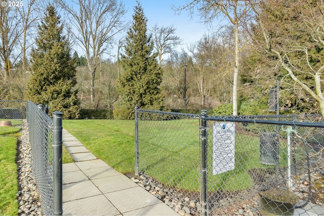 view of gate with fence and a lawn