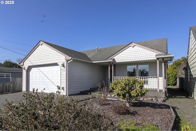 view of front facade featuring an attached garage, covered porch, and a shingled roof