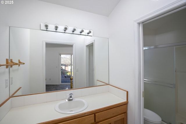 bathroom with toilet, a stall shower, and vanity