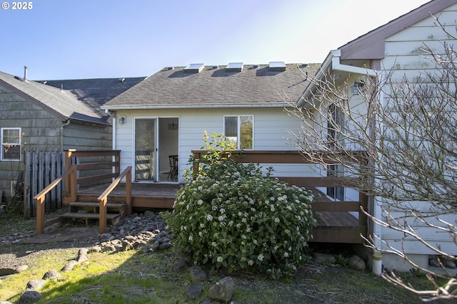 back of property featuring roof with shingles and a wooden deck