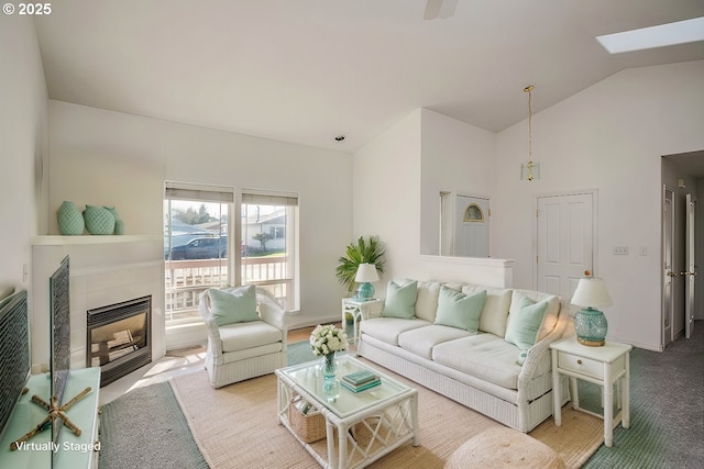 carpeted living area featuring lofted ceiling with skylight and a fireplace