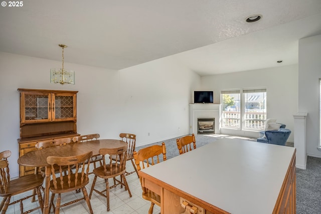 dining area with a notable chandelier, a fireplace, and baseboards