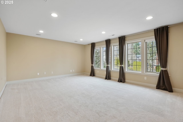 empty room featuring light carpet, baseboards, and recessed lighting