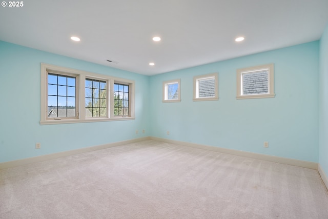 empty room with recessed lighting, light colored carpet, and baseboards