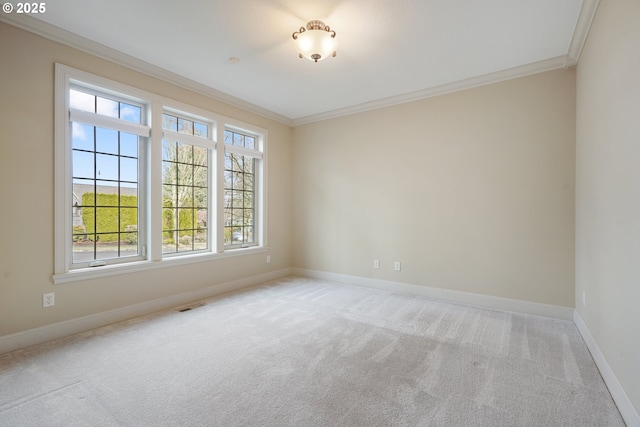 spare room featuring light colored carpet, visible vents, crown molding, and baseboards