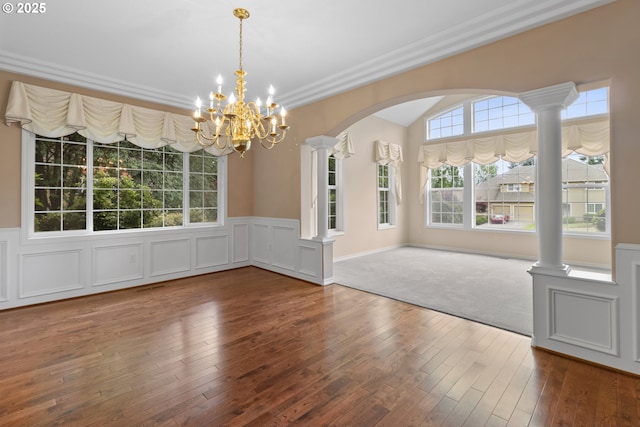 4220 NE 171st Ave, Vancouver, WA 98682 - unfurnished dining area with wood-type flooring, a chandelier, arched walkways, a wainscoted wall, and ornate columns