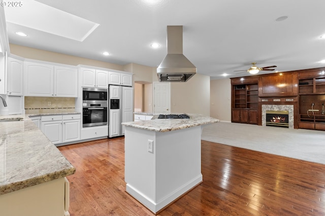 4220 NE 171st Ave, Vancouver, WA 98682 - kitchen featuring island exhaust hood, built in appliances, a center island, a ceiling fan, and light wood-type flooring