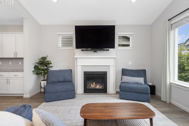 31380 NW Turel Dr, North Plains, OR 97133 - living area with light wood-type flooring, a glass covered fireplace, recessed lighting, and baseboards