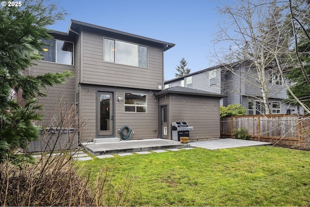 rear view of house with a lawn and a patio