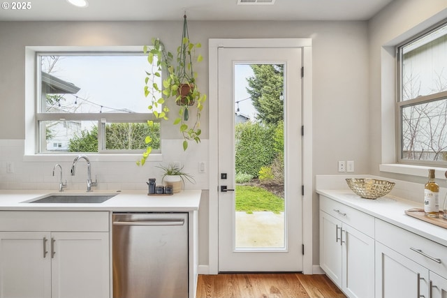 doorway to outside with sink, plenty of natural light, and light hardwood / wood-style floors