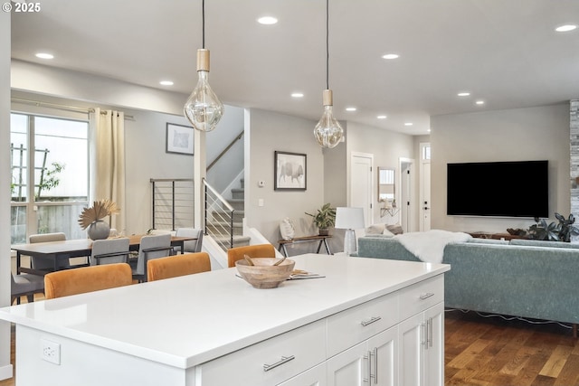 kitchen with white cabinetry, dark hardwood / wood-style floors, a center island, and hanging light fixtures