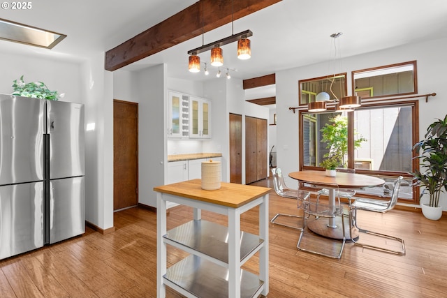 3115 NW Cornell Rd, Portland, OR 97210 - kitchen with freestanding refrigerator, a chandelier, white cabinetry, glass insert cabinets, and beamed ceiling