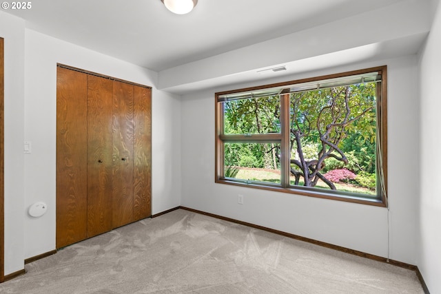 3115 NW Cornell Rd, Portland, OR 97210 - unfurnished bedroom with carpet floors, baseboards, multiple windows, and a closet