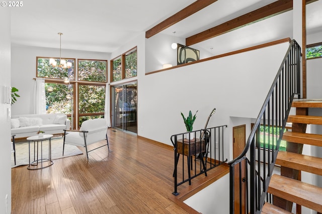 3115 NW Cornell Rd, Portland, OR 97210 - living room with healthy amount of natural light, stairs, wood finished floors, a chandelier, and beamed ceiling