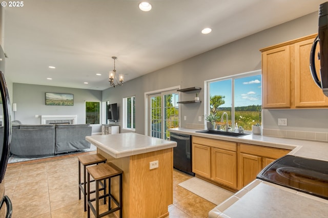 30809 NW Yorkshire St, North Plains, OR 97133 - kitchen with black dishwasher, a sink, a kitchen island, light tile patterned floors, and recessed lighting