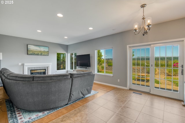 30809 NW Yorkshire St, North Plains, OR 97133 - living area featuring a tile fireplace, recessed lighting, baseboards, light wood-style floors, and a chandelier