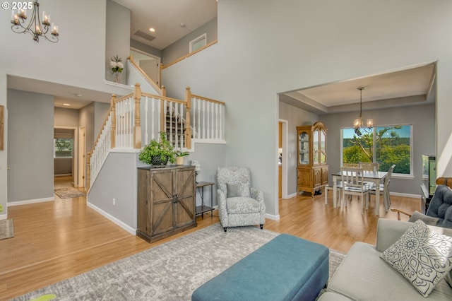 30809 NW Yorkshire St, North Plains, OR 97133 - living room featuring a chandelier, wood finished floors, baseboards, stairway, and a high ceiling