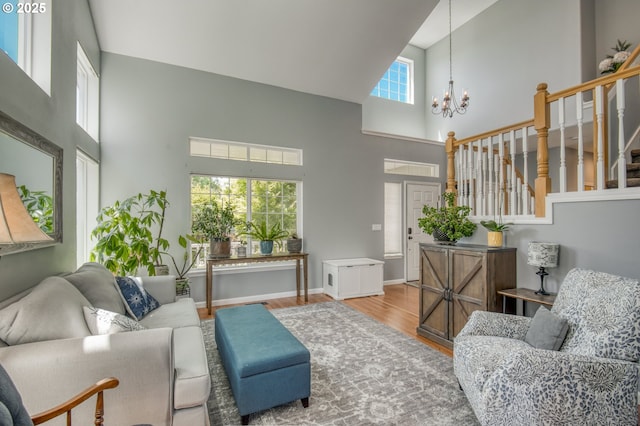 30809 NW Yorkshire St, North Plains, OR 97133 - living room featuring a high ceiling, a chandelier, wood finished floors, stairs, and baseboards