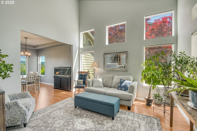 30809 NW Yorkshire St, North Plains, OR 97133 - living area featuring a chandelier, wood finished floors, a towering ceiling, and baseboards