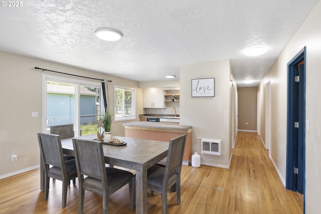 11547 NE San Rafael St, Portland, OR 97220 - dining area featuring light wood-type flooring, baseboards, and a textured ceiling