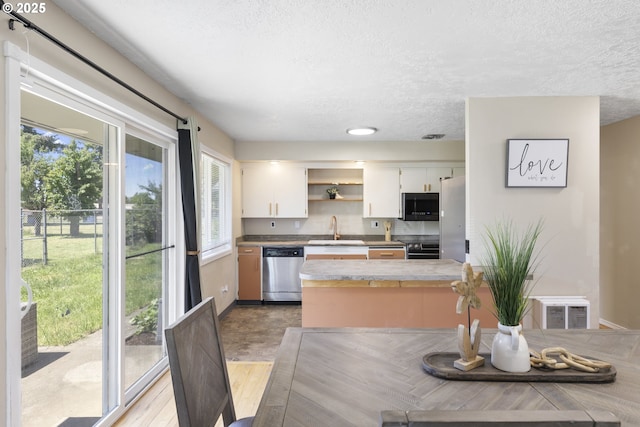 11547 NE San Rafael St, Portland, OR 97220 - kitchen with stainless steel appliances, a textured ceiling, a sink, open shelves, and white cabinetry