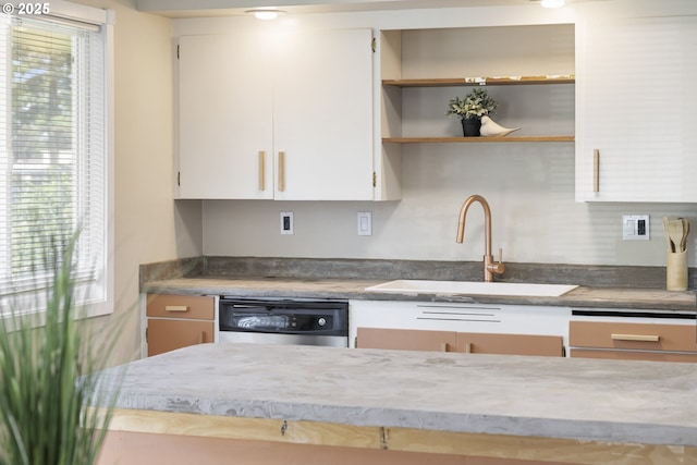 11547 NE San Rafael St, Portland, OR 97220 - kitchen with stainless steel dishwasher, a sink, healthy amount of natural light, and white cabinets