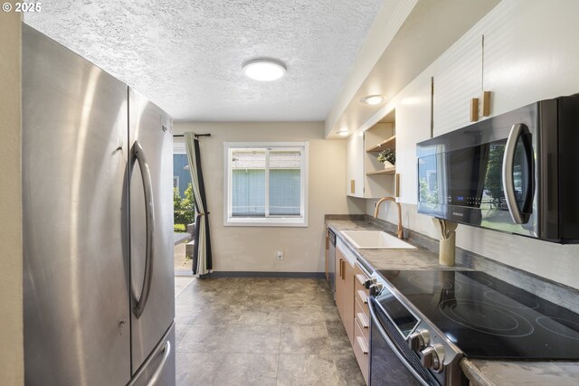11547 NE San Rafael St, Portland, OR 97220 - kitchen with stainless steel appliances, a sink, open shelves, baseboards, and a textured ceiling