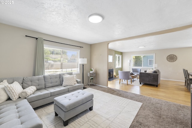 11547 NE San Rafael St, Portland, OR 97220 - living room featuring healthy amount of natural light, carpet floors, arched walkways, baseboards, and a textured ceiling