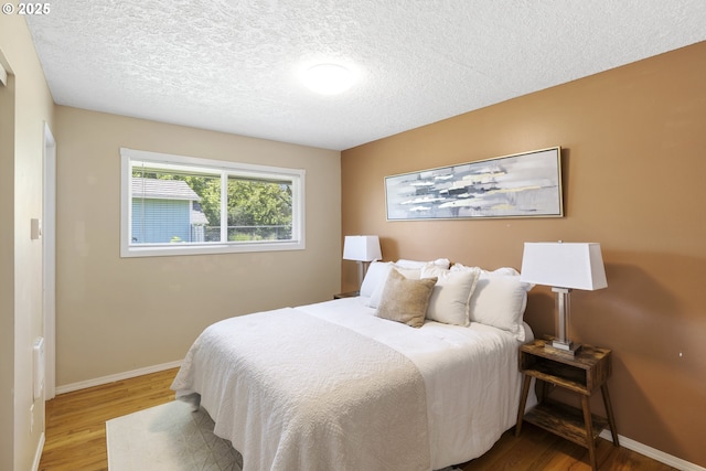 11547 NE San Rafael St, Portland, OR 97220 - bedroom with wood finished floors, a textured ceiling, and baseboards