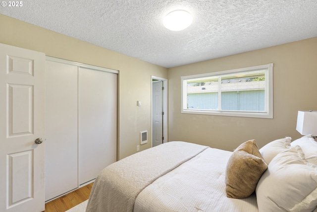 11547 NE San Rafael St, Portland, OR 97220 - bedroom featuring light wood-style flooring, a closet, and a textured ceiling