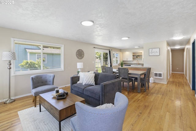 11547 NE San Rafael St, Portland, OR 97220 - living area featuring baseboards, light wood-style flooring, and a textured ceiling