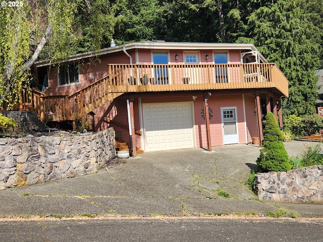 view of front of house featuring a garage, driveway, and stairway