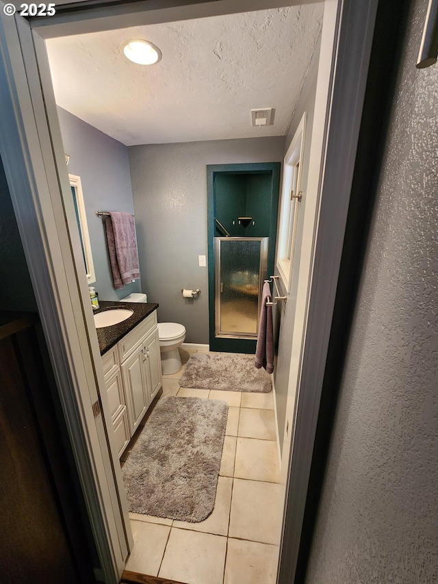 full bathroom with visible vents, tile patterned flooring, a stall shower, vanity, and toilet