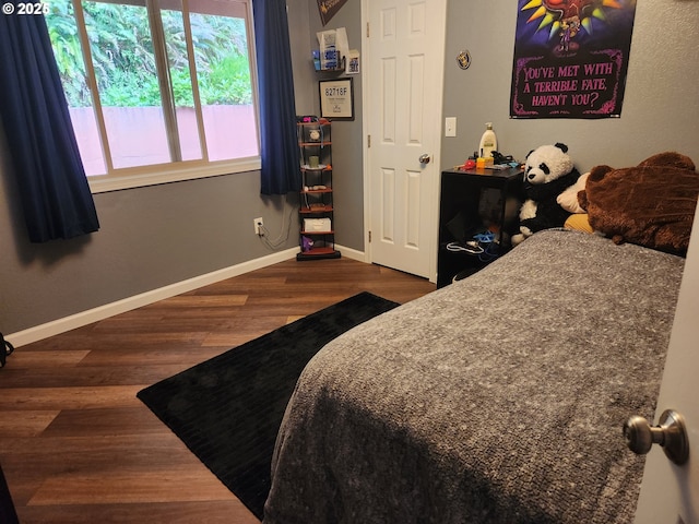bedroom featuring baseboards and wood finished floors