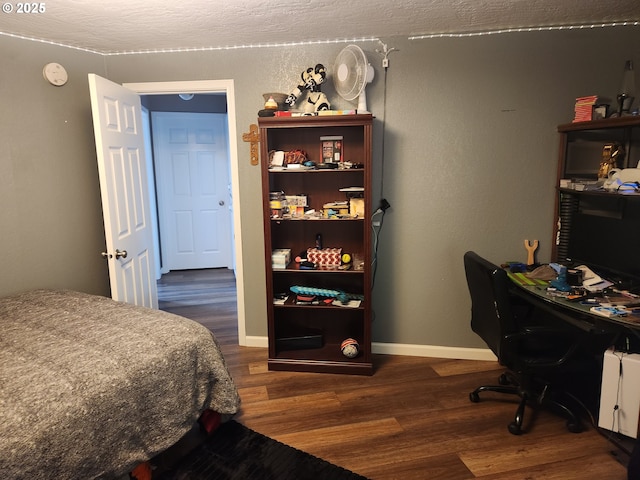 bedroom with baseboards and dark wood-type flooring