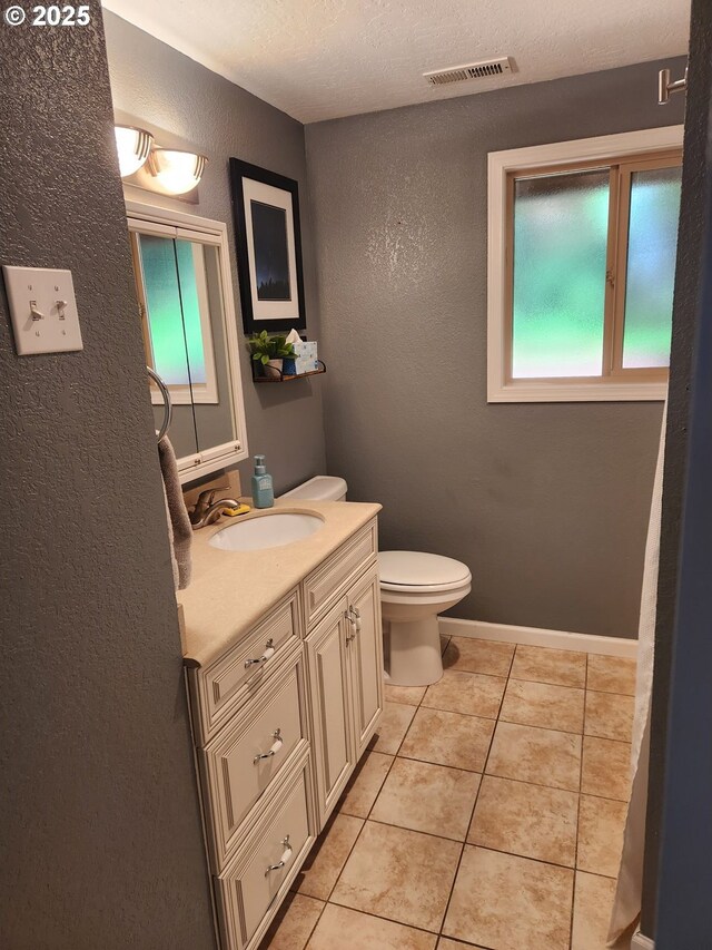 2453 Stephanie Ln, North Bend, OR 97459 - half bath featuring a textured wall, vanity, toilet, and tile patterned flooring