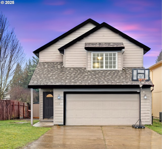 view of front facade featuring an attached garage, a shingled roof, fence, driveway, and a lawn