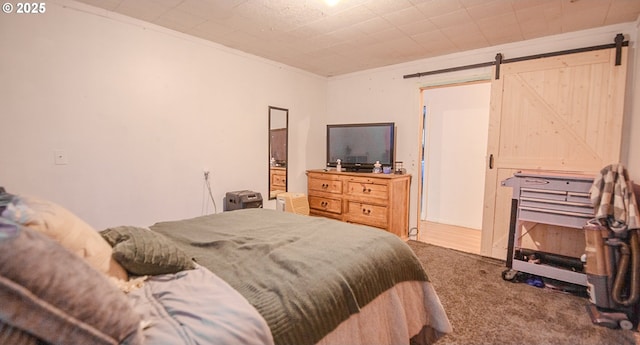 bedroom with ornamental molding, a barn door, and carpet floors