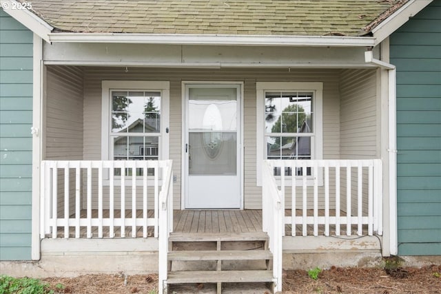 property entrance featuring a porch and a shingled roof