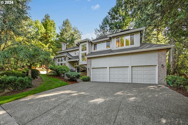 view of front facade with driveway, brick siding, and an attached garage