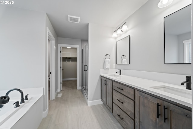 4342 S 16th Way, Ridgefield, WA 98642 - full bathroom with a stall shower, a garden tub, double vanity, a walk in closet, and baseboards