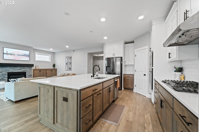 4342 S 16th Way, Ridgefield, WA 98642 - kitchen featuring under cabinet range hood, a sink, stainless steel appliances, light wood-style floors, and white cabinetry