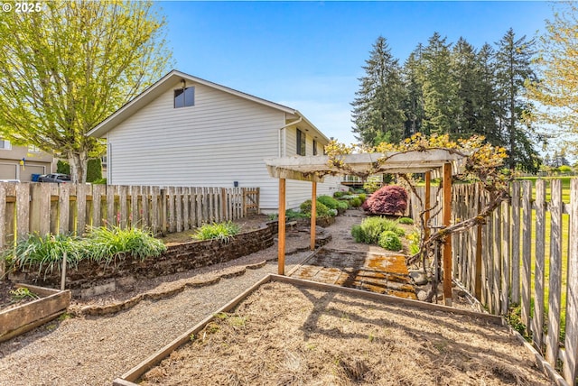 view of yard with a pergola, a garden, and a fenced backyard