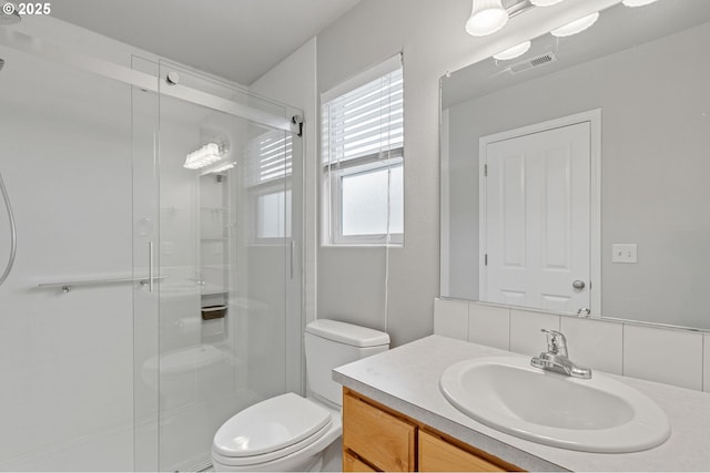 bathroom with visible vents, vanity, toilet, and a shower stall