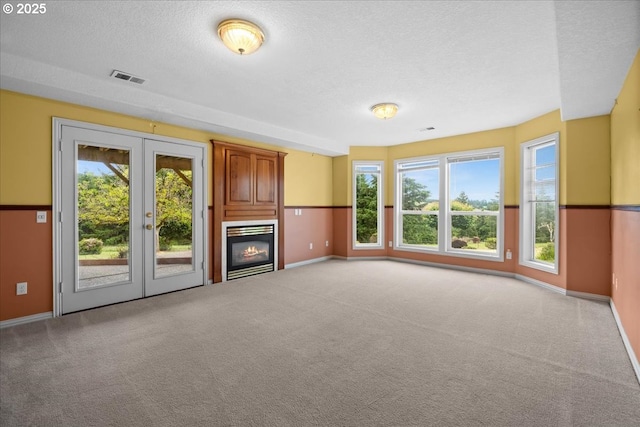 14255 SW Parmele Rd, Gaston, OR 97119 - unfurnished living room featuring baseboards, a textured ceiling, plenty of natural light, french doors, and carpet flooring