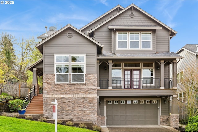 craftsman-style home with an attached garage, stone siding, concrete driveway, stairs, and a balcony