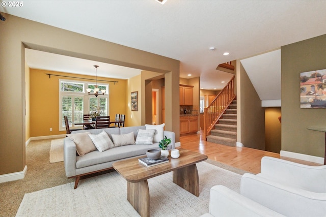 living room featuring a chandelier, stairs, baseboards, and recessed lighting