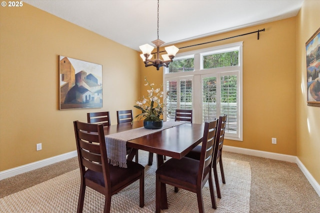 dining area with baseboards, an inviting chandelier, and light carpet